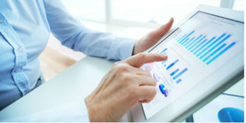 A woman useing a tablet to look at data on a graph in the PointClickCare software