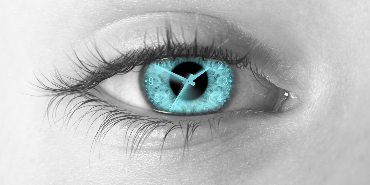 A close up of an eye with a clock overlayed on the pupil