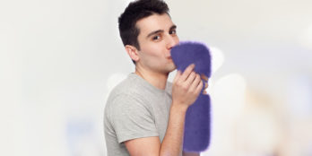 A young man holding a purple plushy to depict the soft side of Skilled Nursing Data