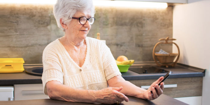 An elderly resident using her smartphone to get help with and details about her diabetes