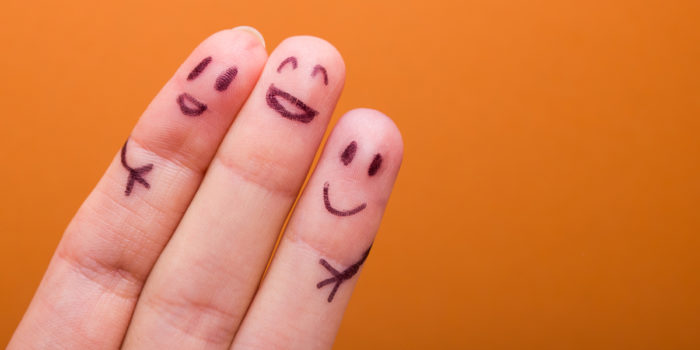 Three fingers with smiling stick figures drawn on them