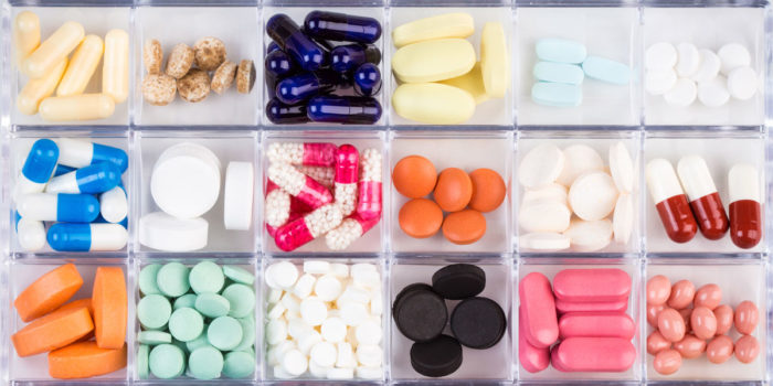 A close up of a pill organizer with various diffferent medications in it