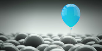 One blue baloon rising above a crowd of grey baloons to signify standing out from the competition as occupancy declines