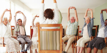 A group of elderly people reducing their chances of rehospitalization by stretching as part of one of their therapeutic classes