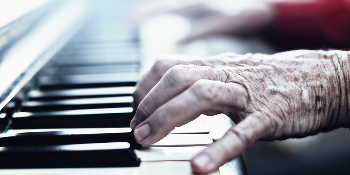 A senior woman's hands playing a piano