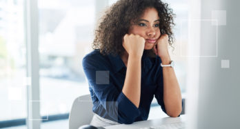 Stressed healthcare worker due to PDPM changes with fists up to her face while looking a at monitor