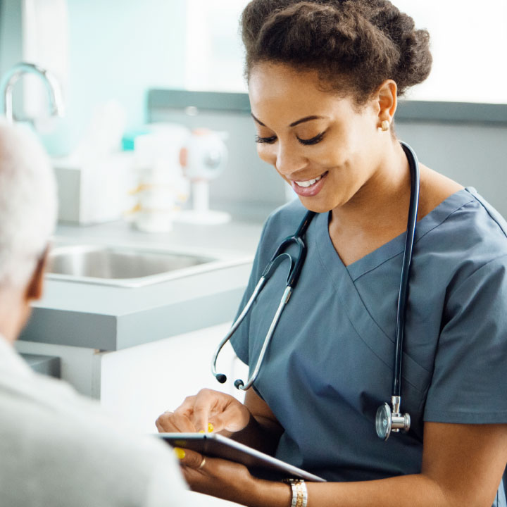 A nurse using the Performance Insights product on a tablet device while speaking with a resident