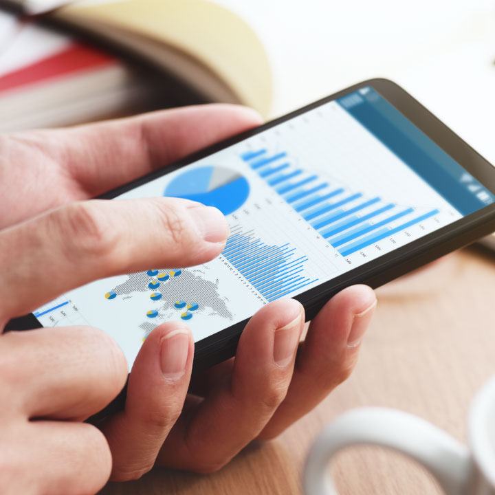 Hands using PointClickCare's Performance Insights product on a mobile device to review real-time data