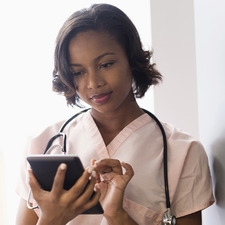 A home care registered nurse inputting client information to the EMR software on a mobile device