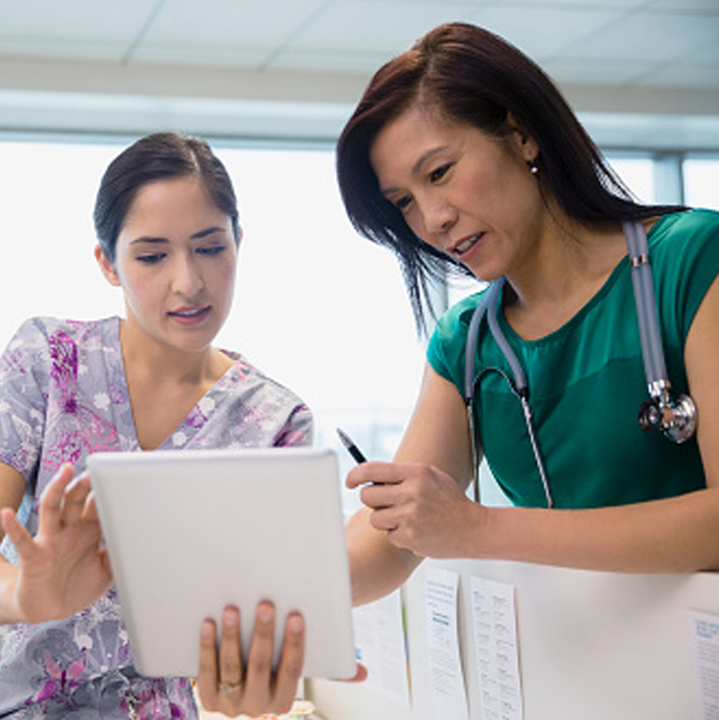 A female nurse and female doctor reviewing patient data on a tablet