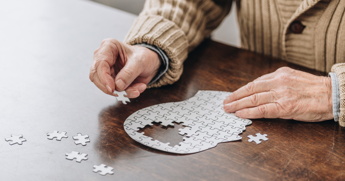 A photo showing a senior working on a puzzle at a table.