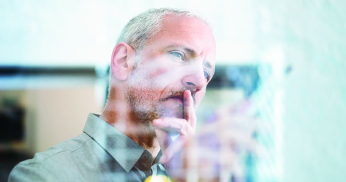 A male CFO stares intently at a computer screen.