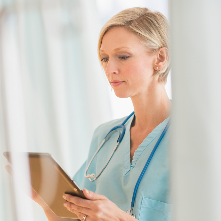 A nurse using the PointClickCare EMR on a tablet