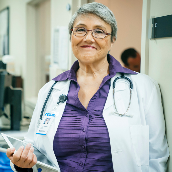 A Director of Nursing / Administrator smiling after using carequality with the tablet in her hands