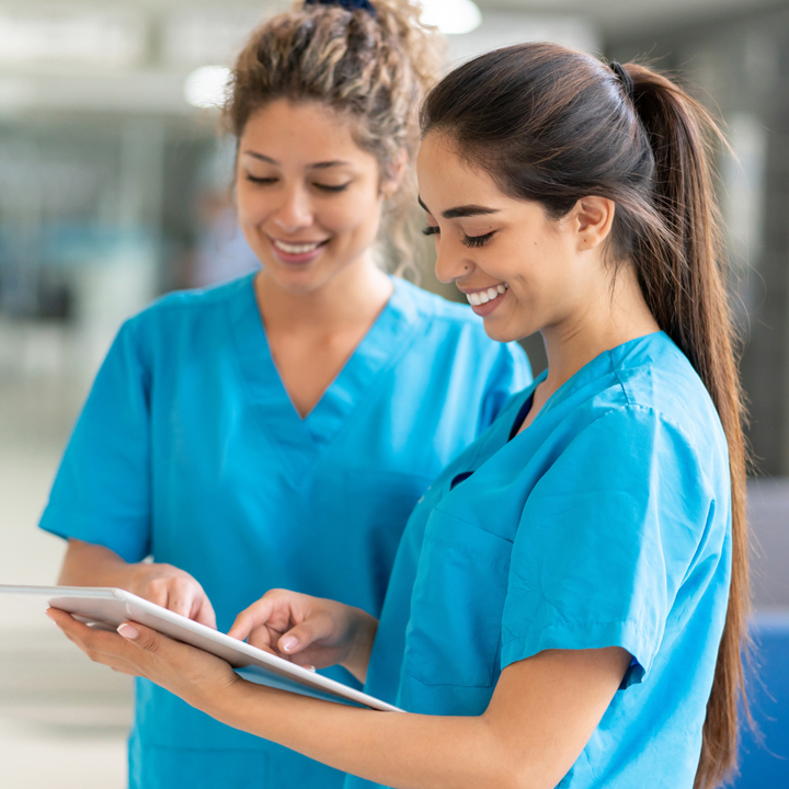 Two female nurses using a tablet devices and reviewing Infection Prevention and Control best practices