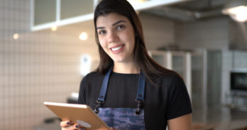 A server at a Senior Living community smiles while taking an order.