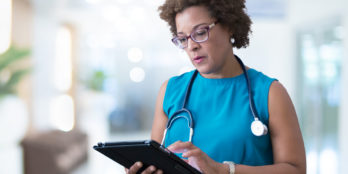Female doctor using insights from patient data from the PointClickCare platform to make better decisions
