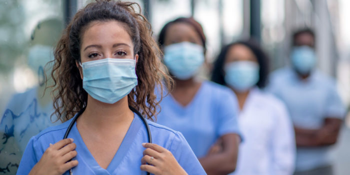 4 skilled nursing providers with their face masks on standing outside of their facility during the COVID-19 pandemic