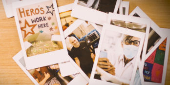 Close up of a desk with printed photos scattered all over it