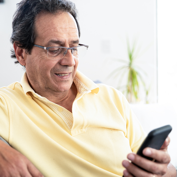 Male senior living resident sitting and reviewing information on a mobile device