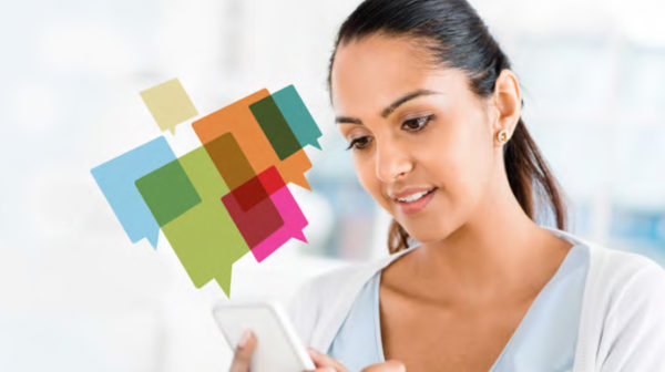 Female using a mobile device with several colored chat box icons graphics overlay above the phone