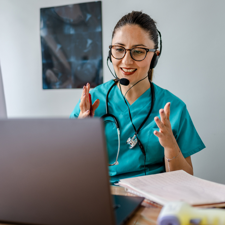 Female hospitalist providing telemedicine services via video call on laptop using PointClickCare's Virtual Health solution