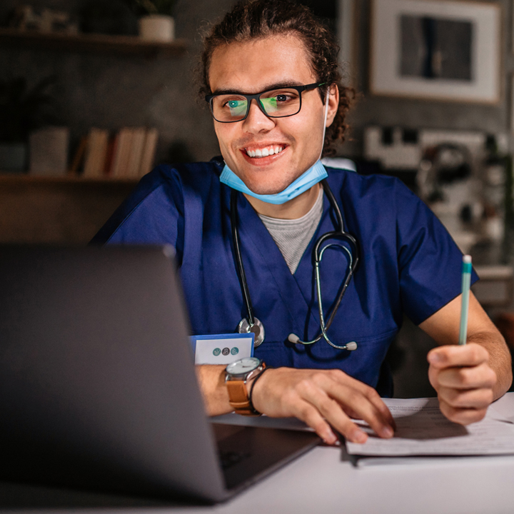 Male hospitalist providing telemedicine services via video call on laptop using PointClickCare's Virtual Health solution