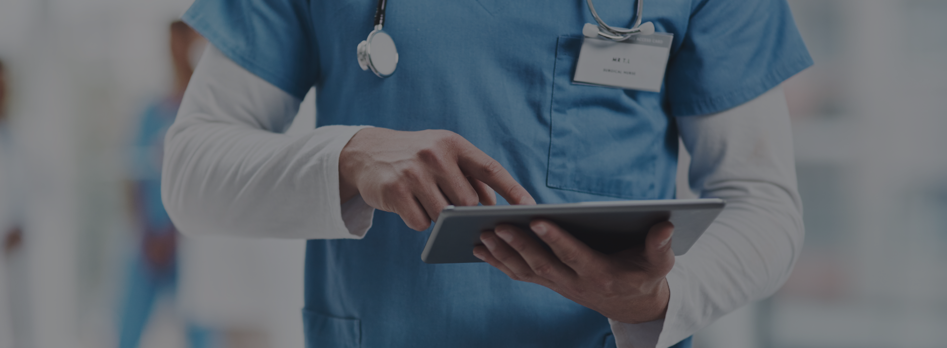 Close up of a skilled nursing provider's hands holding and using a tablet device in a medical environment
