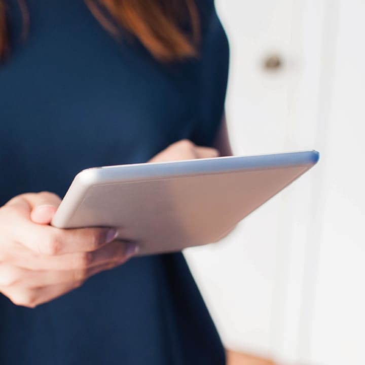 Close up of a female's hands holding a tablet device