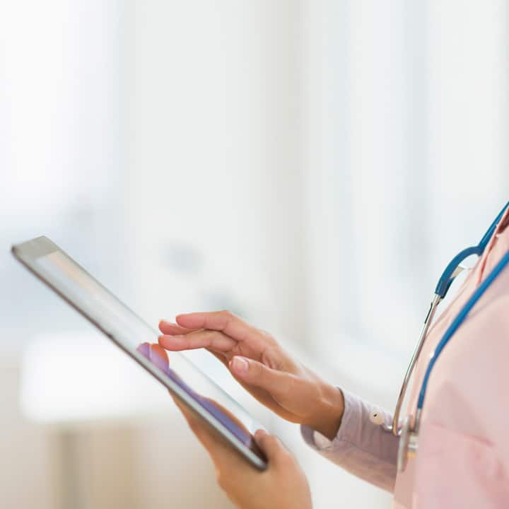 Close up of a female doctors' hands holding and using a tablet device